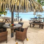 Tables et chaises en bord de plage à Fakarava, cadre idyllique pour un repas au bord du lagon